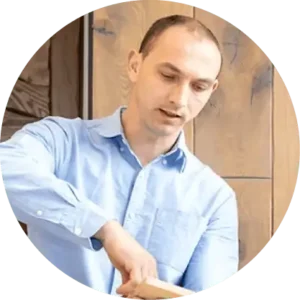 Man in light blue shirt working at laptop indoors