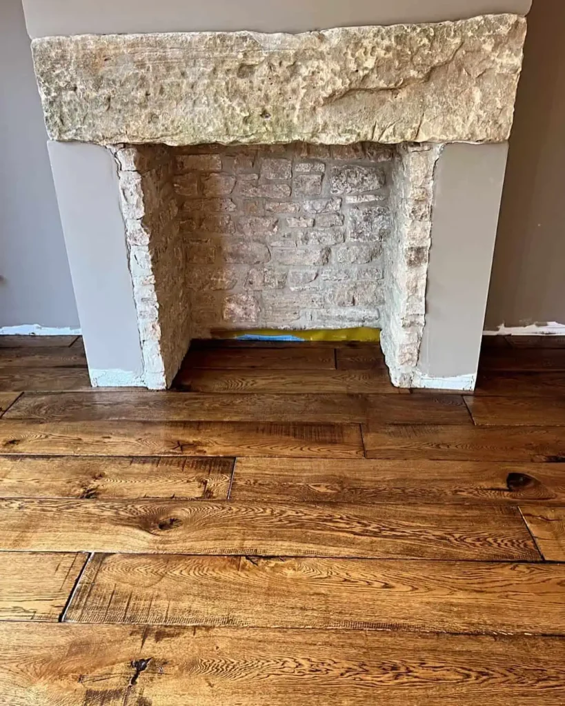 Restored fireplace with white painted brick and wooden floor
