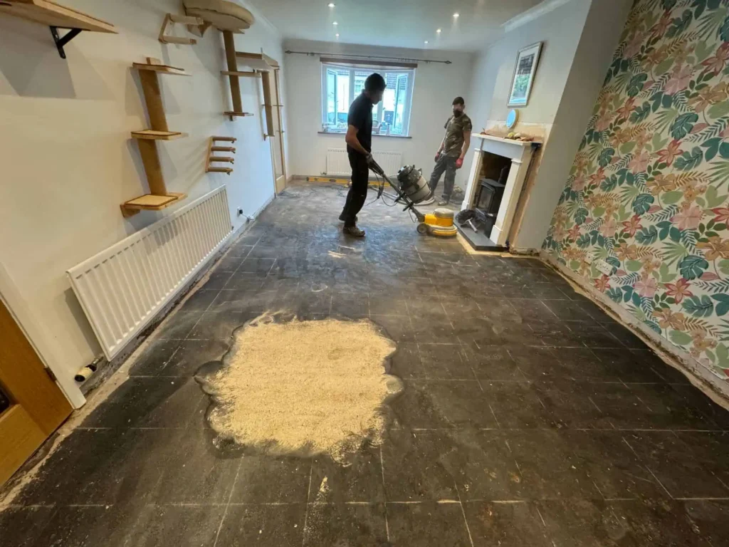 Workers using floor sanding machine during home renovation