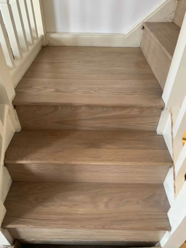 Wooden staircase with white walls and railings
