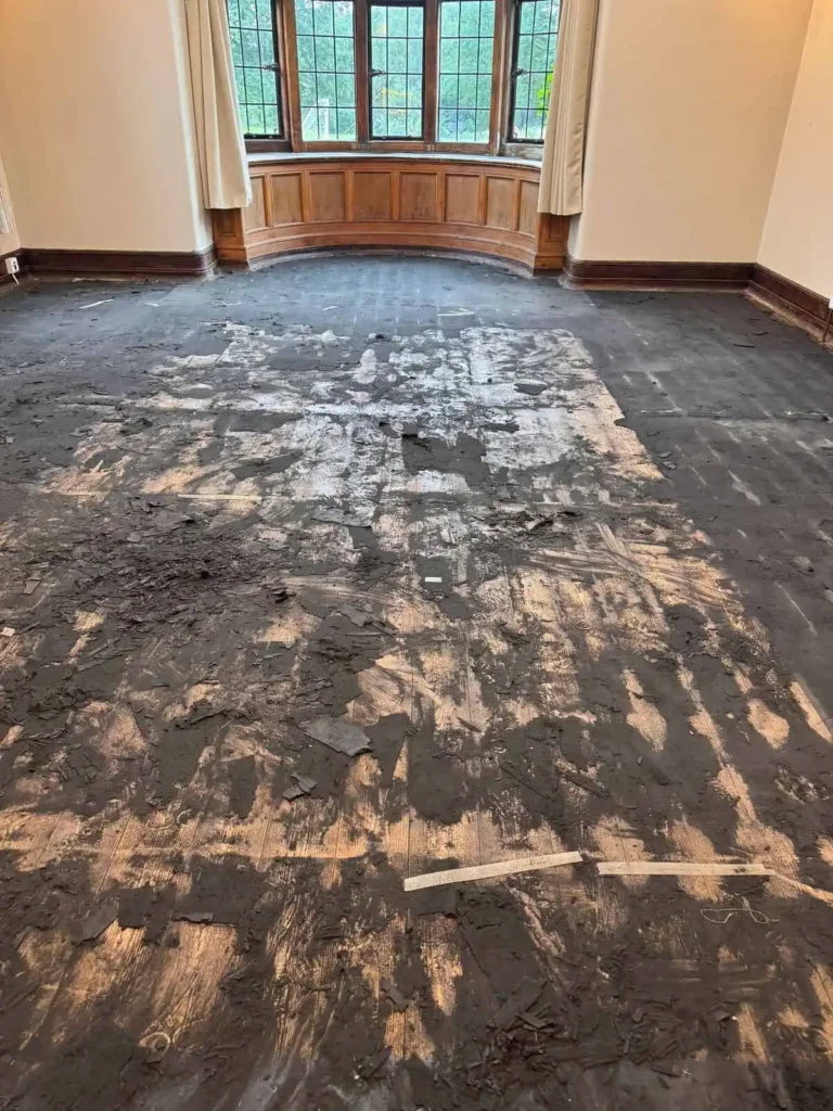 Damaged hardwood floor with peeling coating in elegant room