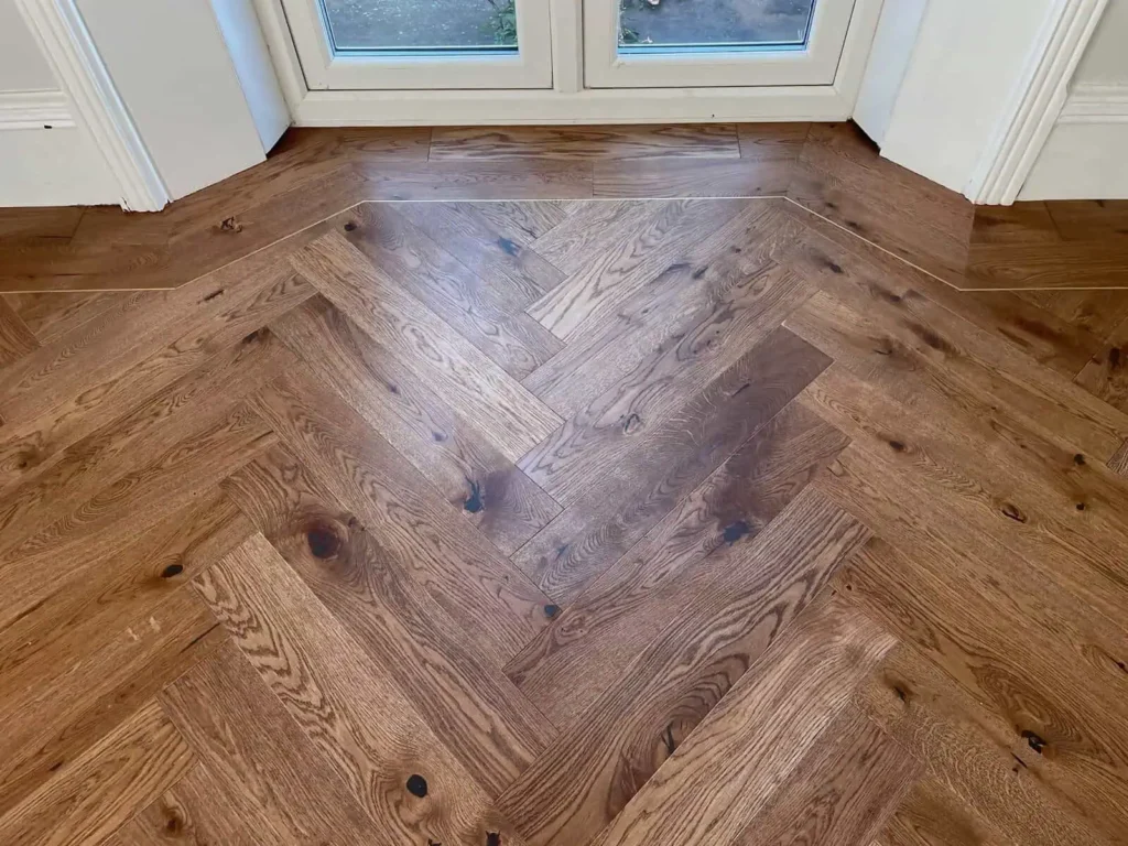 Herringbone wood flooring with French doors and white trim