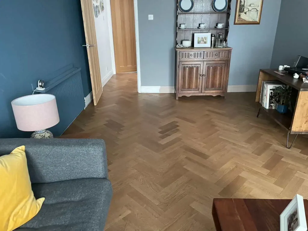 Modern living room with herringbone wood flooring and blue walls