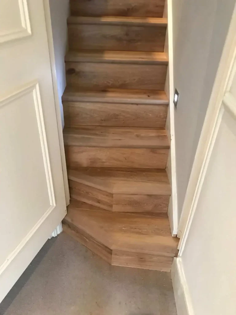 Wooden staircase with white walls and handrails