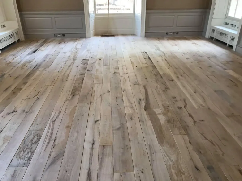 Empty garage with light wood flooring and grey doors