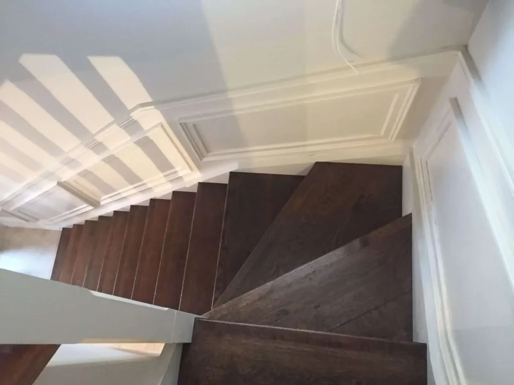 Modern staircase with dark wood steps and white ceiling trim