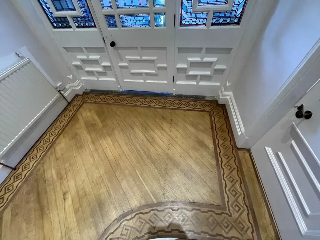 Elegant hallway with wooden flooring and stained glass doors
