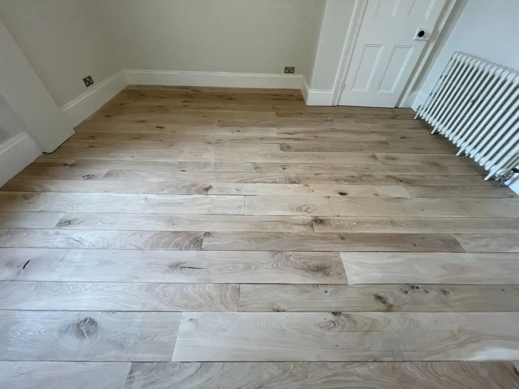 Empty room with newly installed light wood laminate flooring