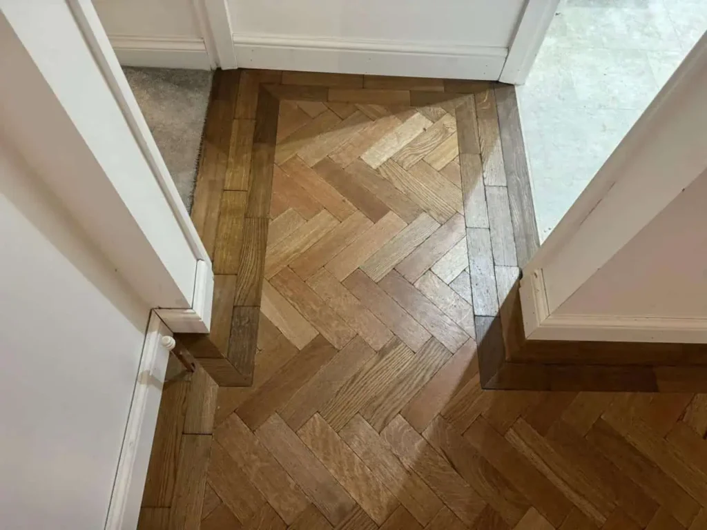 Herringbone wooden flooring with white door frames
