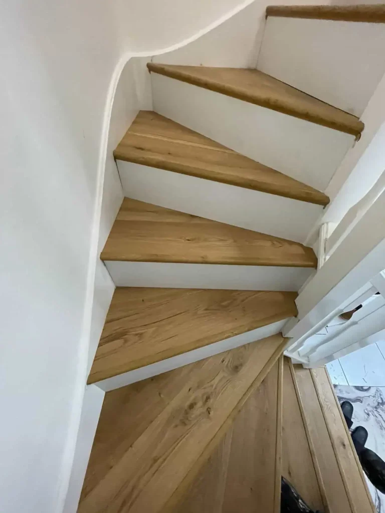 Modern wooden staircase with white risers and handrails