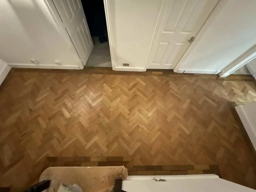 Herringbone parquet wooden floor with white interior doors