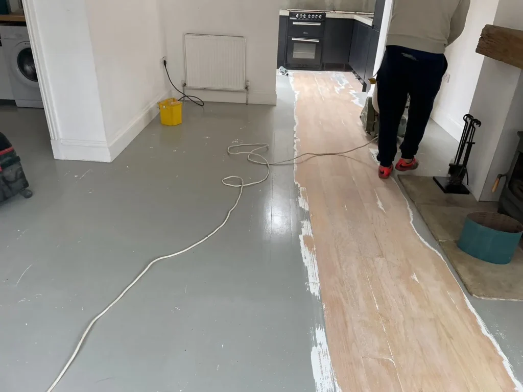 Kitchen renovation in progress with flooring installation and protective coverings