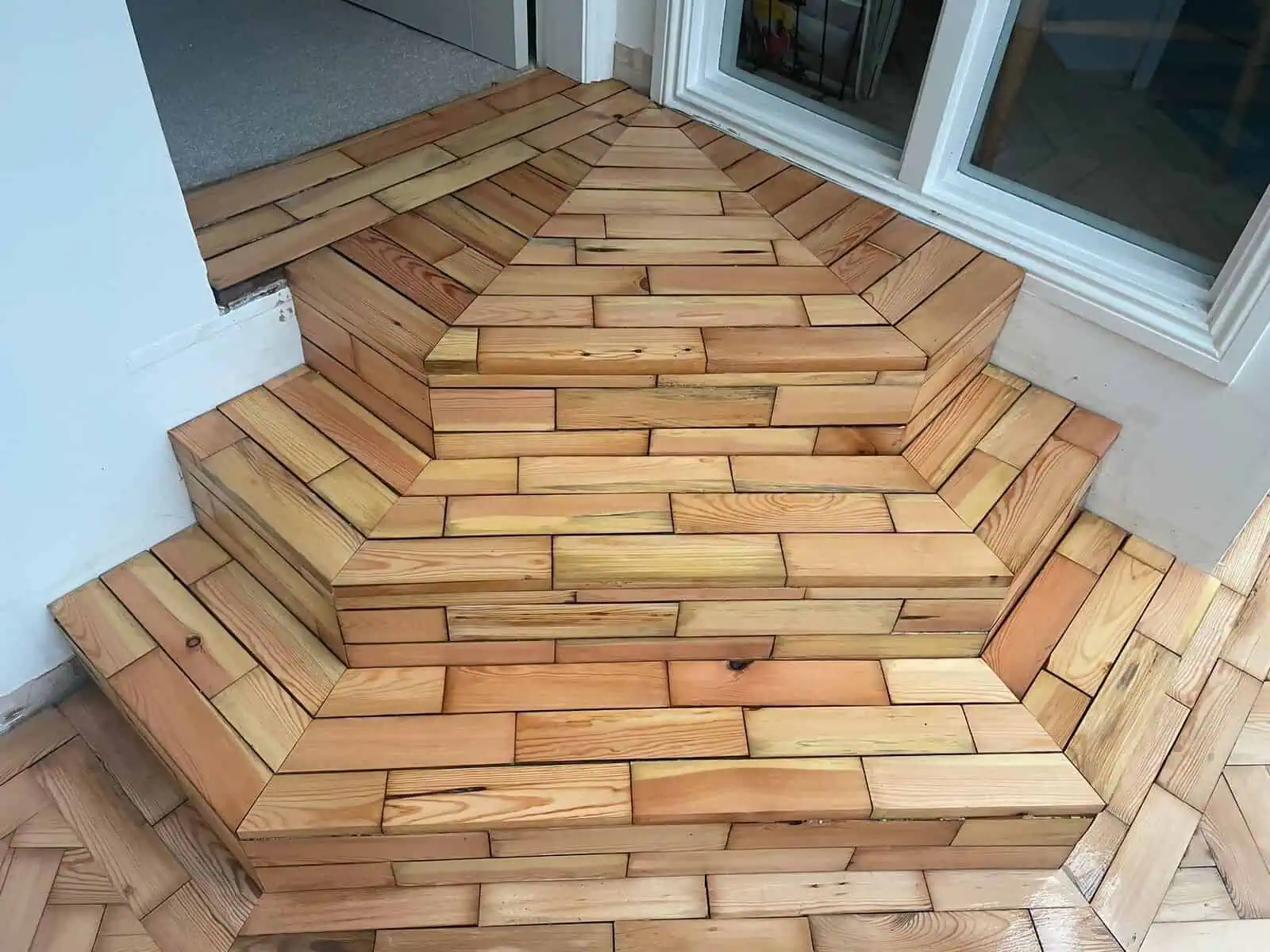 Wooden herringbone flooring transition between indoor and outdoor spaces