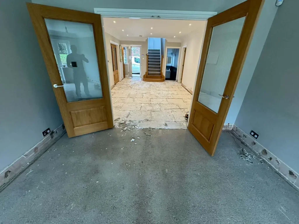Home renovation in progress with open wooden doors and exposed flooring