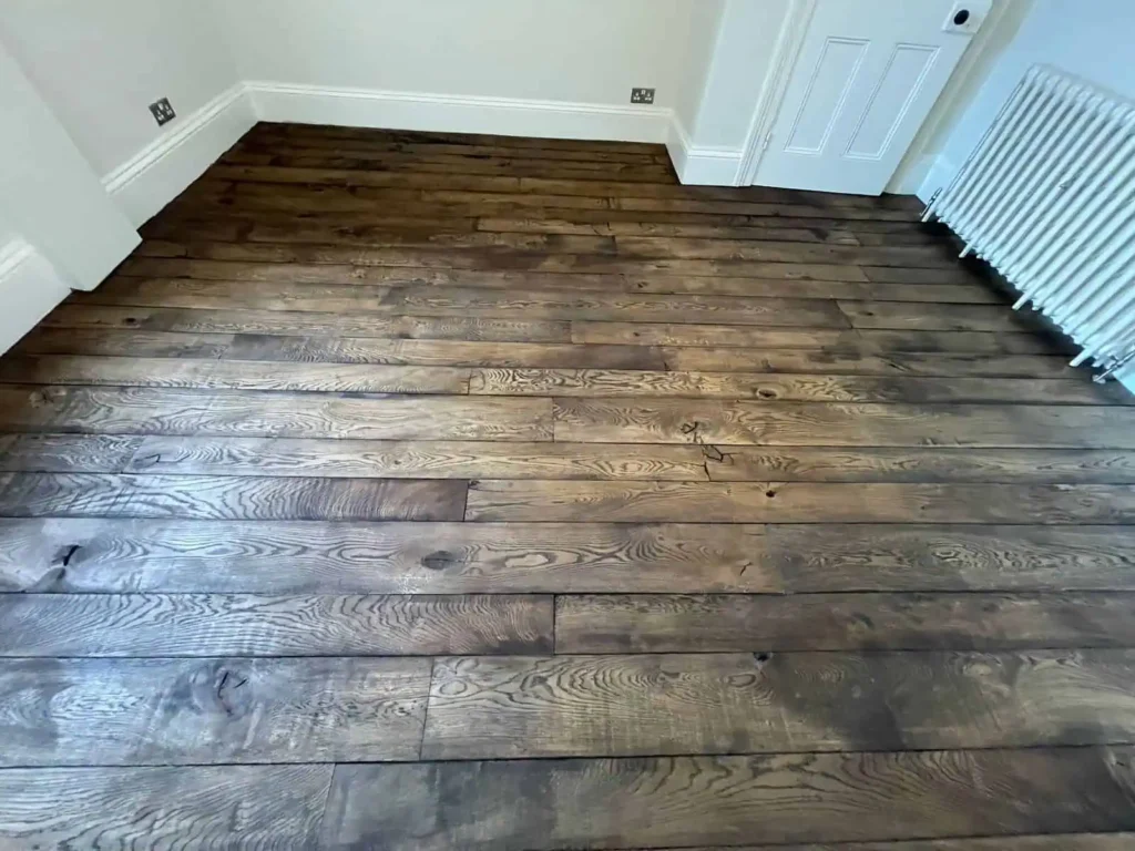 Dark wood plank flooring in modern room with white walls