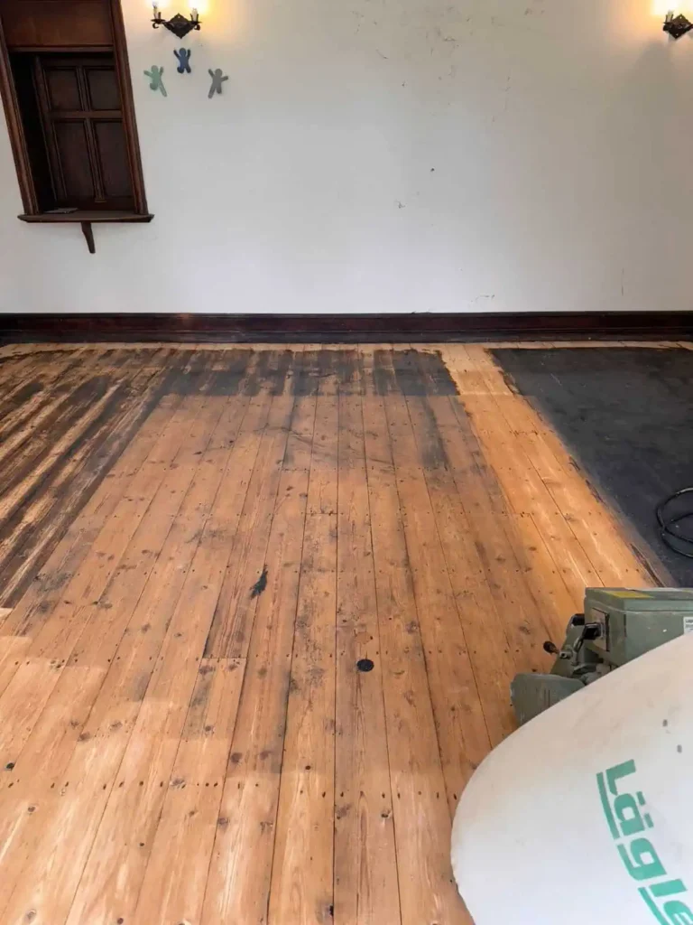 Wooden floorboards in empty room with white walls