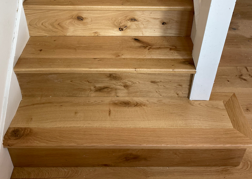 Wooden staircase with white painted walls and natural wood steps