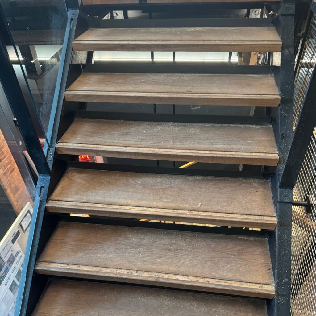 Wooden staircase with dark metal frame and handrails