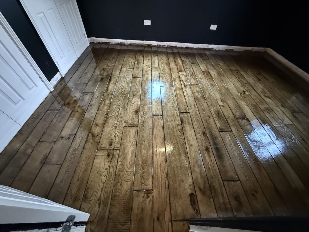 Wooden floor with dark walls and white door frame