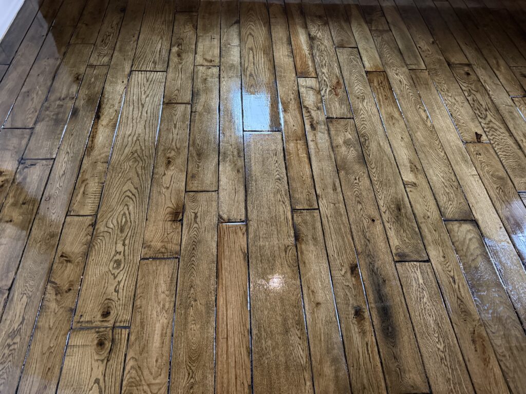 Wooden parquet floor with light blue painted rectangular patch