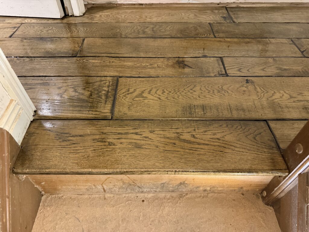 Wooden plank flooring with transition threshold and white trim