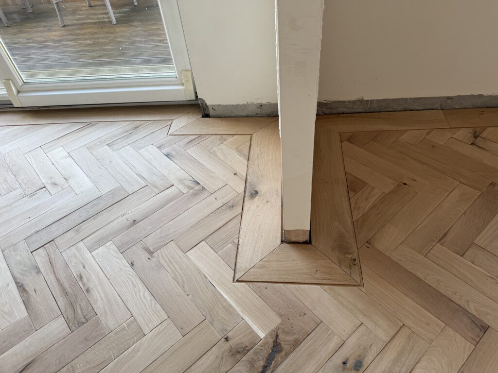 Herringbone wooden flooring with skylight and white column