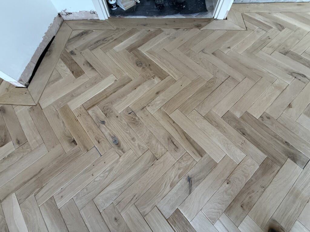 Light wood herringbone pattern flooring in modern interior