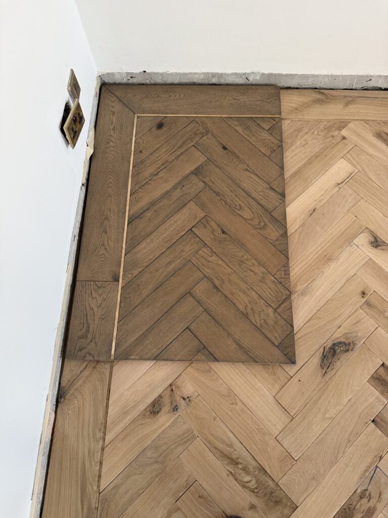 Wooden herringbone parquet flooring with border detail