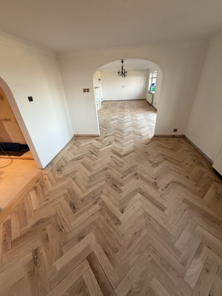 Spacious open-plan living room with herringbone wood flooring