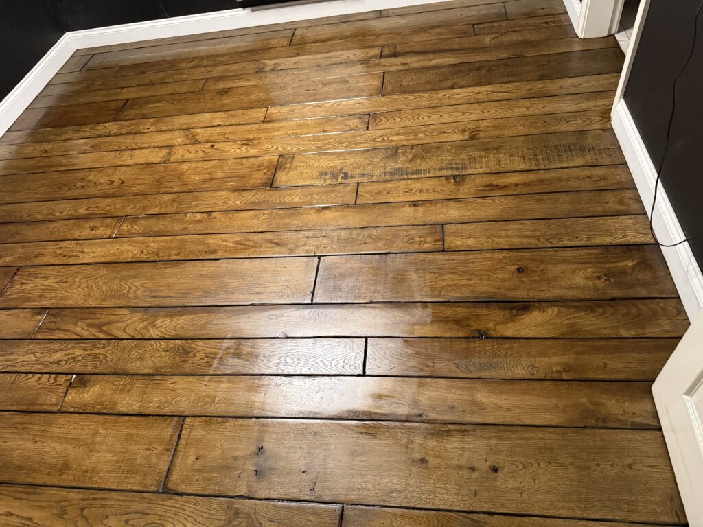 Wooden hardwood floor with random plank pattern and white trim