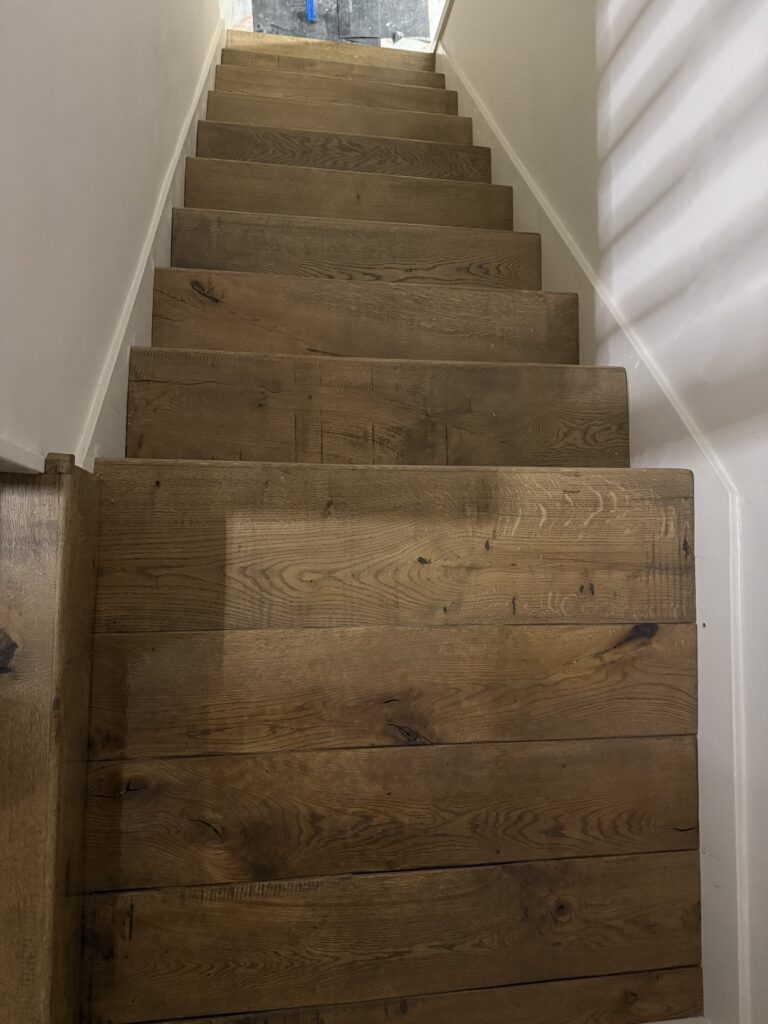 Wooden staircase with natural oak steps and white walls