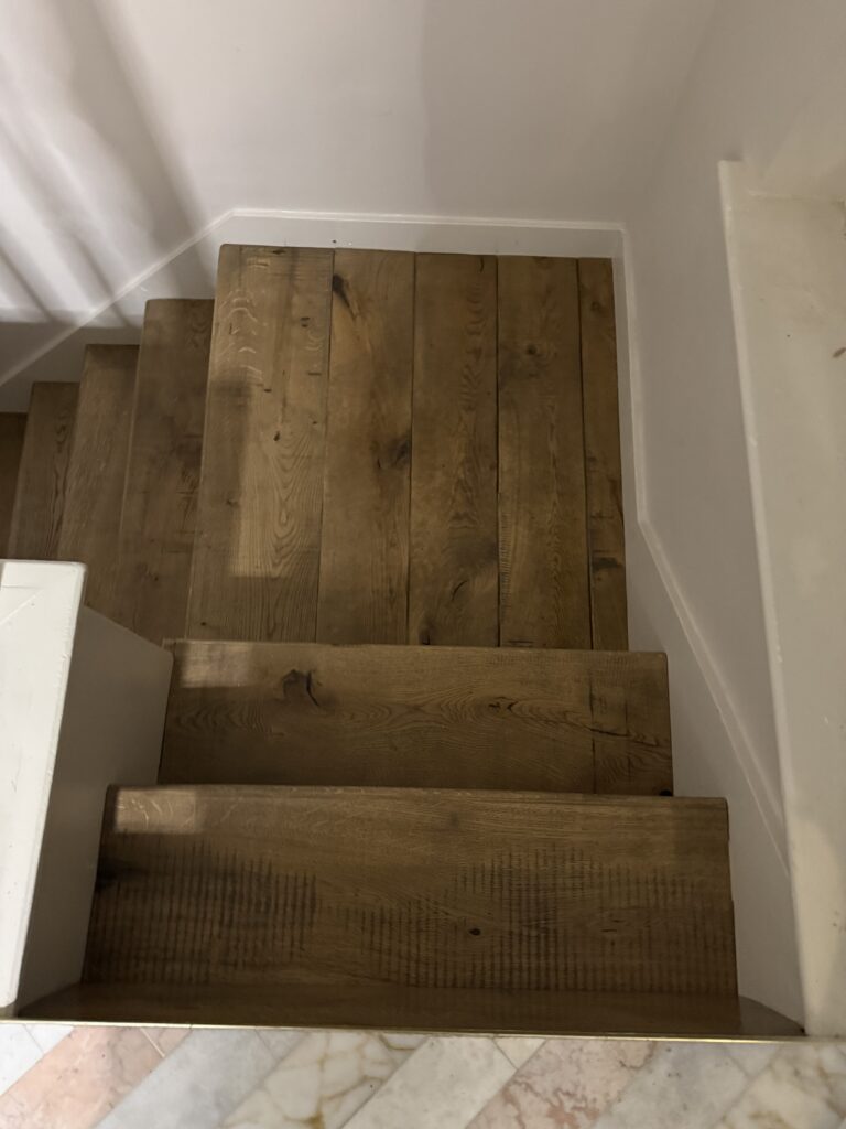 Wooden staircase with white trim and landing