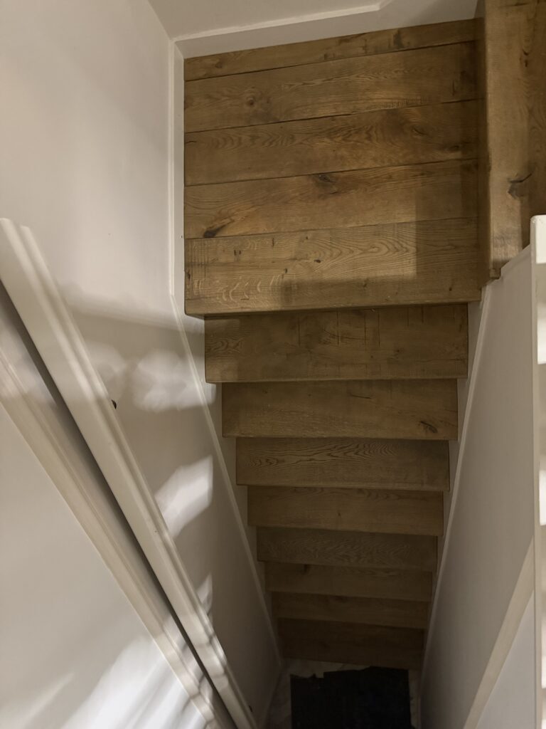 Wooden staircase with white walls and railings