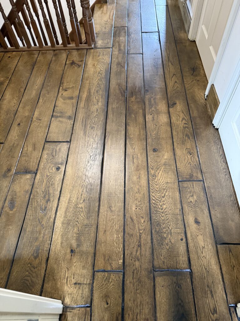 Dark wood plank flooring in herringbone pattern, hallway