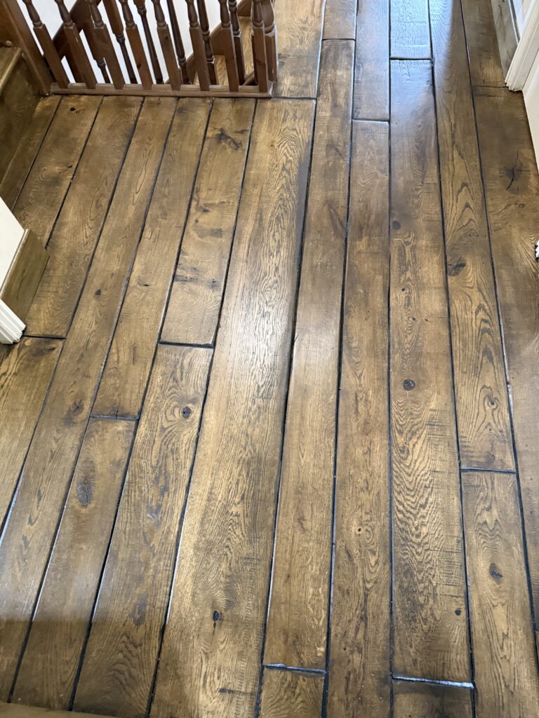 Brown hardwood floor with staircase and wooden railing